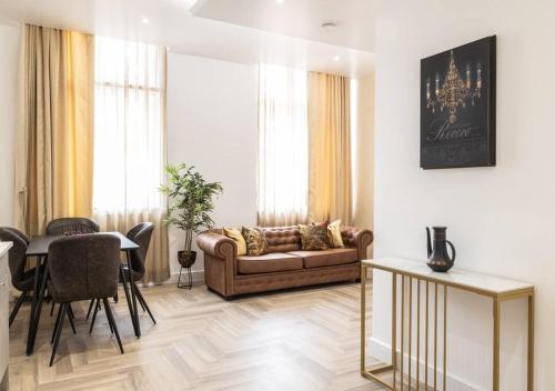 ein Wohnzimmer mit einem Sofa und einem Tisch in der Unterkunft The Pocklington - The Bradgate Suite in Leicester