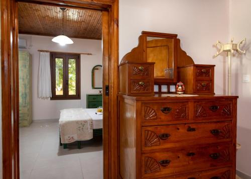 a bathroom with a dresser and a bedroom with a bed at Elisavet's House in Plataniás