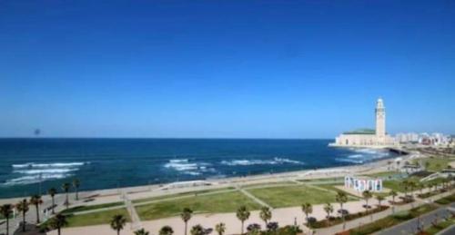 - une vue sur la plage avec un phare et l'océan dans l'établissement Lhaja home, à Casablanca