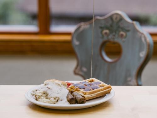 a plate of food with waffles and potatoes on a table at Enzian Inn in Leavenworth