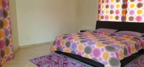 Lhaja home في الدار البيضاء: غرفة نوم مع سرير مع لحاف ملون