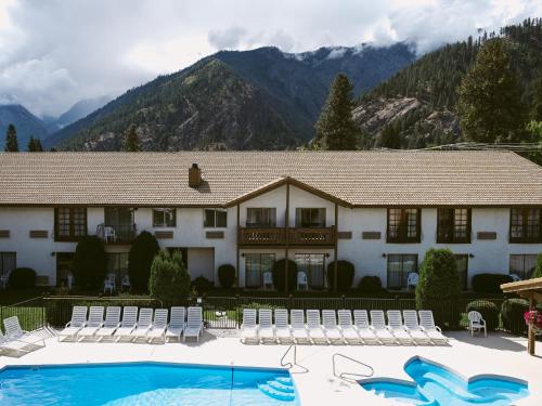 a resort with a pool and chairs and a building at Enzian Inn in Leavenworth