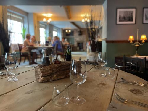 a group of wine glasses sitting on a wooden table at White Hart Hotel in Wiveliscombe