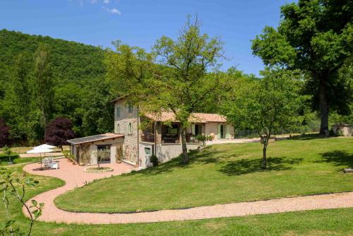 ein Haus auf einem Hügel mit einem Rasenplatz in der Unterkunft Lo Smarrino agriturismo in Gubbio
