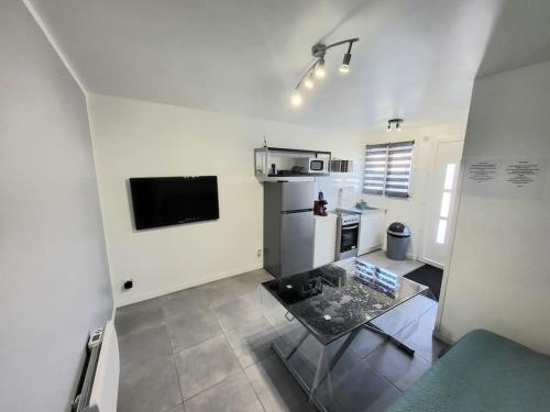 - une cuisine avec une table au milieu d'une pièce dans l'établissement Appartement T2 proche de l’aéroport CDG et Paris, à Claye-Souilly