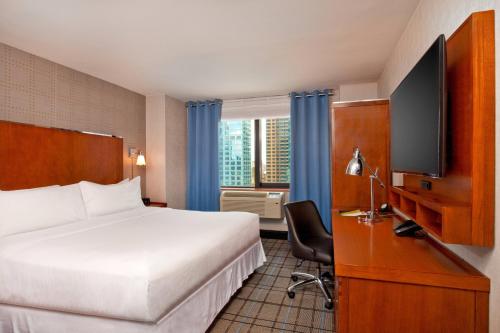 um quarto de hotel com uma cama e uma televisão de ecrã plano em Four Points by Sheraton Midtown - Times Square em Nova York