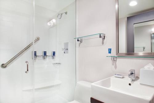 a white bathroom with a shower and a sink at Four Points by Sheraton Midtown - Times Square in New York