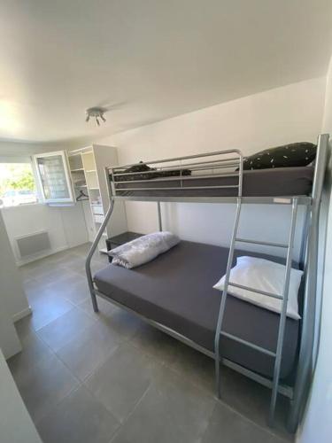 une chambre avec deux lits superposés dans une pièce dans l'établissement Appartement T2 proche de l’aéroport CDG et Paris, à Claye-Souilly