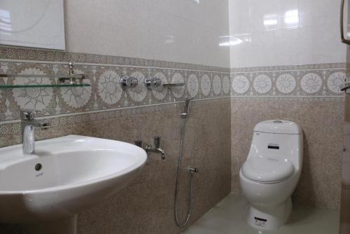 a bathroom with a sink and a toilet at Hotel Milina Uttara in Dhaka