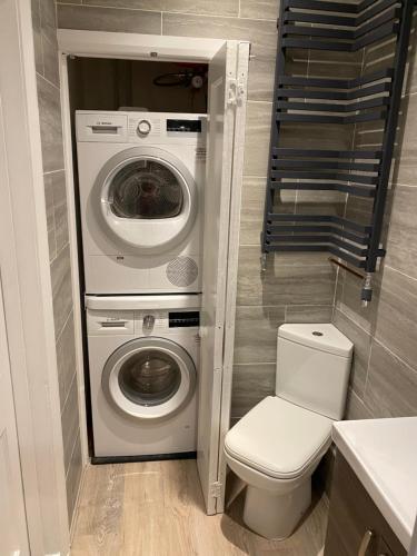 a bathroom with a washing machine and a toilet at Clements House Swanage in Swanage