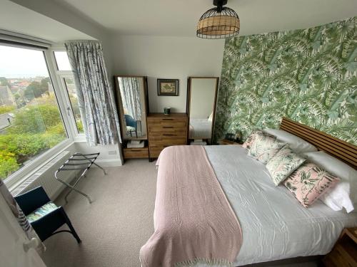 a bedroom with a large bed and a large window at Clements House Swanage in Swanage