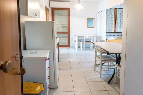 a kitchen with a refrigerator and a table with chairs at SE006 - Senigallia, bilocale sul mare con spiaggia in Senigallia