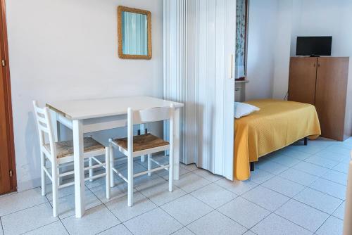 a white table and chairs in a room with a bed at SE006 - Senigallia, bilocale sul mare con spiaggia in Senigallia