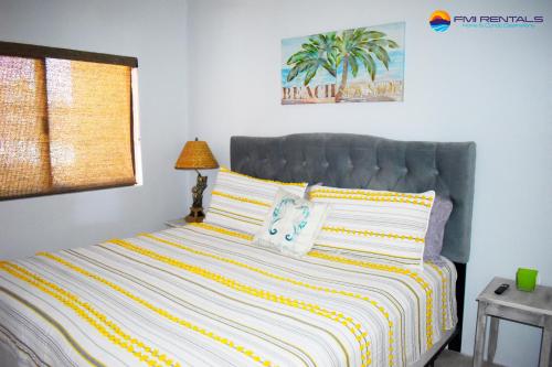 a bedroom with a large bed with yellow and white stripes at Marina Pinacate B-101 in Puerto Peñasco