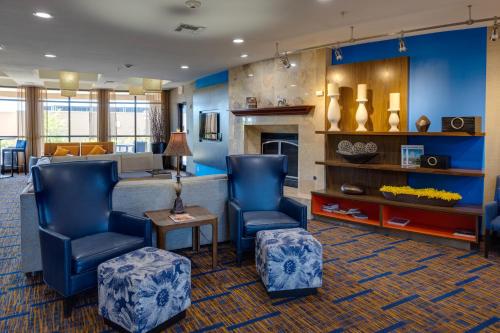 vestíbulo con 2 sillas azules y chimenea en Courtyard by Marriott Oklahoma City North/Quail Springs, en Oklahoma City