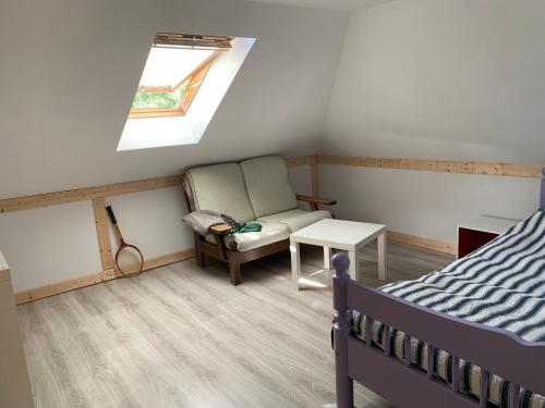 a bedroom with a bed and a chair and a window at Uroczy dom na Mazurach Jezioro Dybowskie in Dybowo