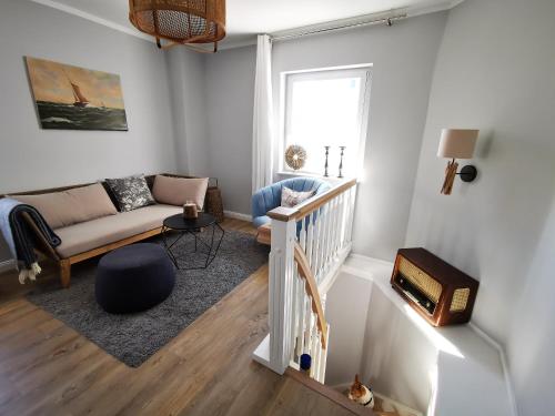 ein Wohnzimmer mit einem Sofa und einem TV in der Unterkunft Homelig Ferienwohnung 1 Altstadt Sassnitz in Sassnitz