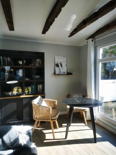 a living room with a table and chairs and a window at Homelig Ferienwohnung 1 Altstadt Sassnitz in Sassnitz