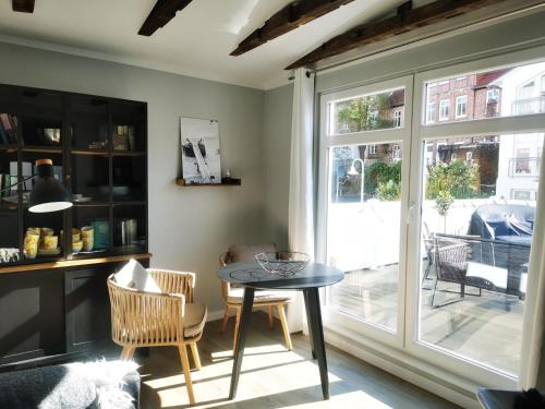 a dining room with a table and chairs and a window at Homelig Ferienwohnung 1 Altstadt Sassnitz in Sassnitz