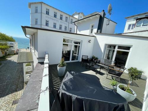 a balcony of a white house with a table and benches at Homelig Ferienwohnung 1 Altstadt Sassnitz in Sassnitz