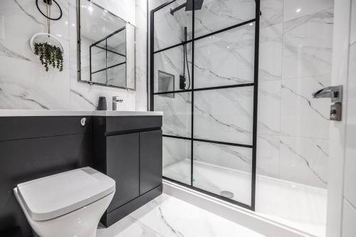 a black and white bathroom with a shower and a toilet at The Pocklington - The Ceremonial Suite in Leicester