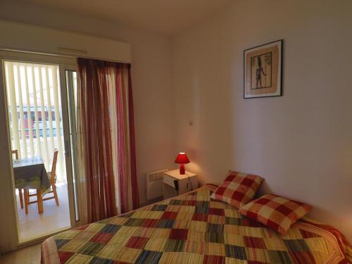 une chambre avec un lit et une porte coulissante en verre dans l'établissement Spacieux 34m² avec clim, WIFI, loggia et terrasse pour 6 pers à Sète - FR-1-472A-182, à Sète