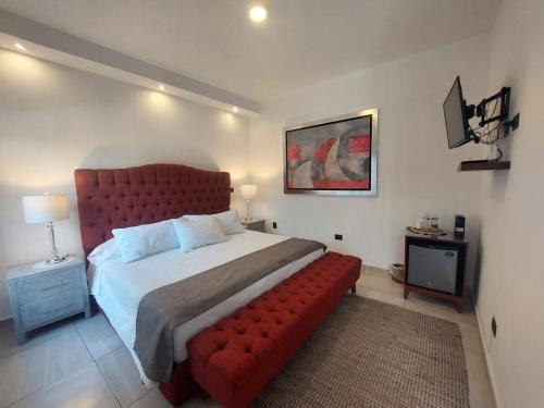 - une chambre avec un grand lit rouge et un canapé rouge dans l'établissement Casa Allende Morelia, à Morelia