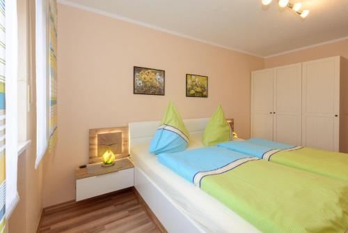ボーデンマイスにあるFerienwohnung-Panoramablick-1のベッドルーム1室(青と緑のシーツが備わるベッド1台付)