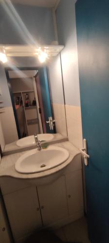 une salle de bain avec un lavabo et un miroir dans l'établissement Studio et parking privé bord de mers, au Cap d'Agde