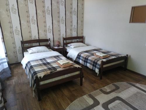 a room with two beds and a rug at Apartment in the center of old town in Kamianets-Podilskyi