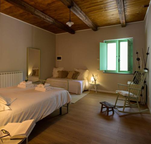 a bedroom with two beds and a chair and a window at Lo Smarrino agriturismo in Gubbio