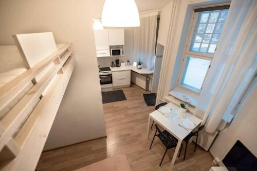 a kitchen and a living room with a table and a window at 2ndhomes Kamppi Apartments 3 in Helsinki