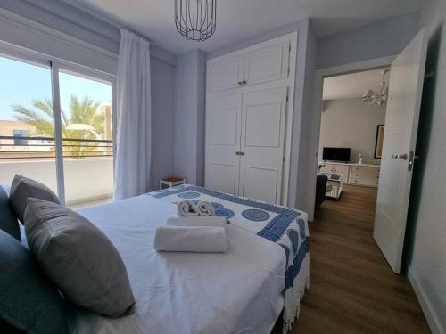 a bedroom with a bed with two towels on it at Santa Monica Suites, 2 hab con terraza, parking y playa a 5 min a pie in Aguadulce