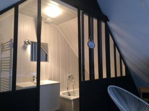 uma casa de banho com uma porta preta com um relógio na parede em LE LOFT DU DOUBS em Besançon