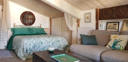 a bedroom with a bed and a couch at La Bohême in Charols