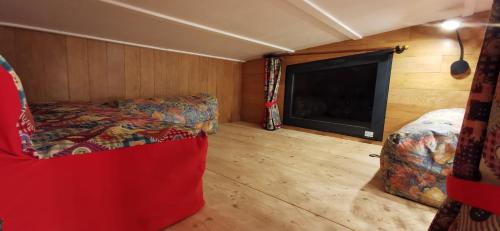 uma sala de estar com uma cama e uma lareira num quarto em La Charmotte, tiny House insolite 