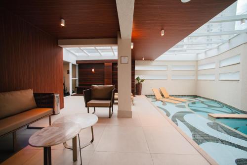 a lobby with a swimming pool in the middle of a building at Brut by Slaviero Hotéis in Balneário Camboriú