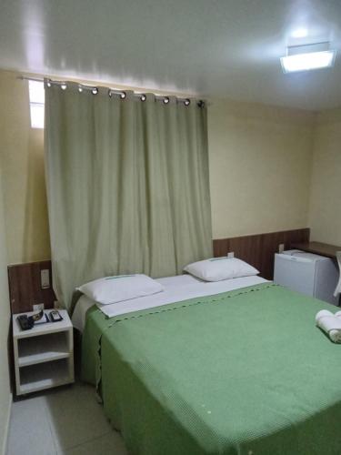 a bedroom with two beds and a green blanket at Pousada Familly -Praia de Tambaú -PB in João Pessoa