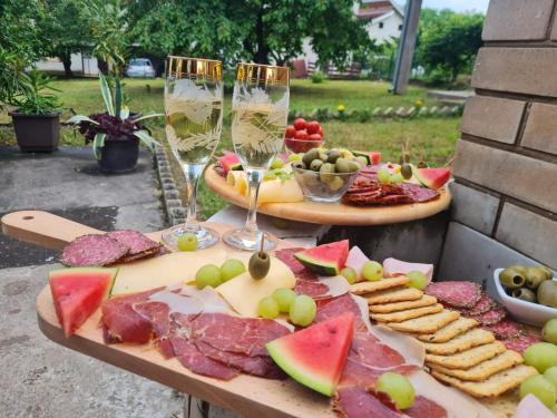 a table with two plates of food and glasses of wine at Libero house in Smederevo