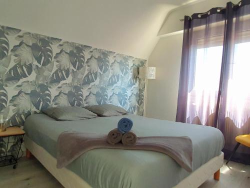 a bedroom with a bed with a blue and white wall at GRENIER DES CIGOGNES in Sélestat