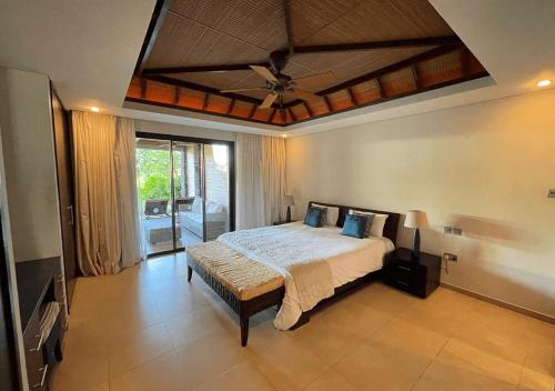 a bedroom with a large bed with a ceiling at Private Beach 5-star Villa, Golf & Luxe in Centre de Flacq