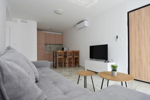 uma sala de estar com um sofá e uma televisão em APART M top apartments close to the center em Murter