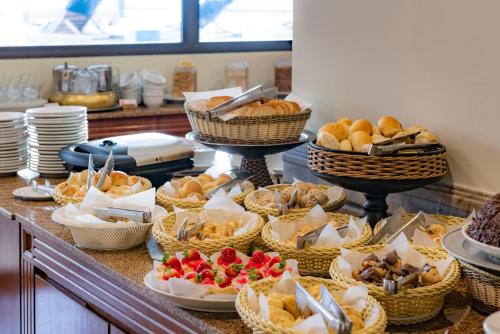 um buffet cheio de cestas de pão e pastelaria em Monreale Plus Midtown Campinas em Campinas