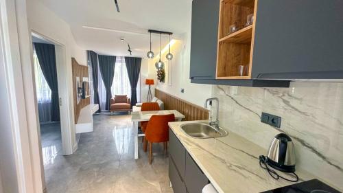 a kitchen with a sink and a table in a room at Happy Apart Hotel in Kuşadası