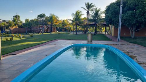 a swimming pool in a yard with a park at Sítio em Guriri in São Mateus