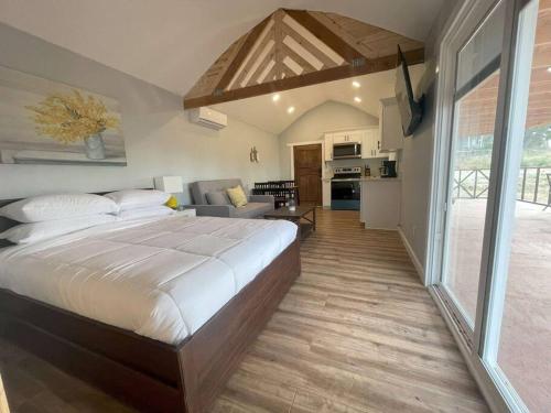 - une chambre avec un grand lit et un salon dans l'établissement Modern wine country barn house, à Temecula