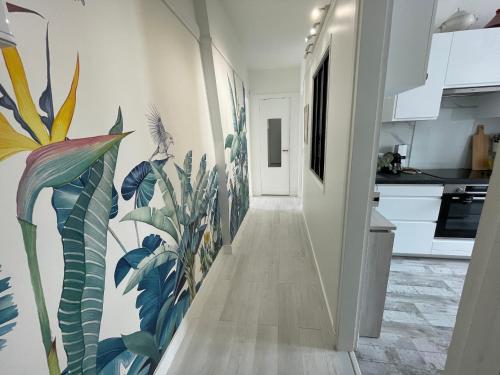 un couloir orné d'une fresque murale représentant des plantes dans l'établissement Appartement 2 pièces élégant proche Porte de Versailles, à Paris