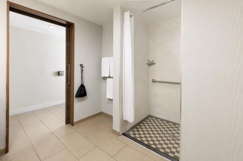 a bathroom with a shower with a glass door at The Anza-a Calabasas Hotel in Calabasas