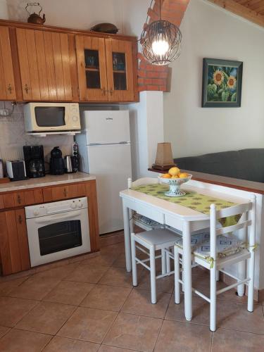 a kitchen with a white table and a white refrigerator at Casa O Cantinho Algarvio in Odeceixe