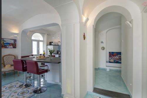 a kitchen and living room with a table and chairs at Ravello Vingius Suite in Ravello